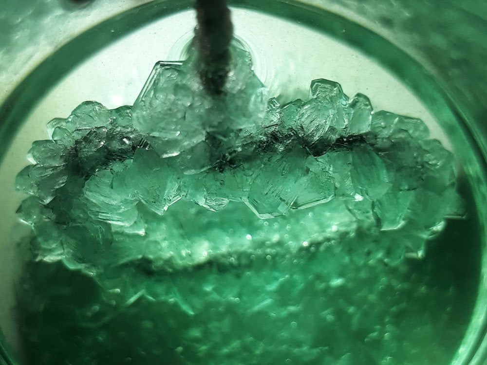Iron sulfate crystals growing on a ring of steel wire