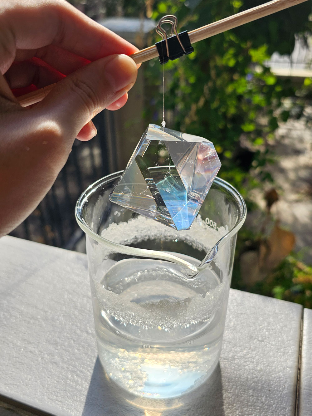 An octahedral alum crystal grown suspended on a fishing line.